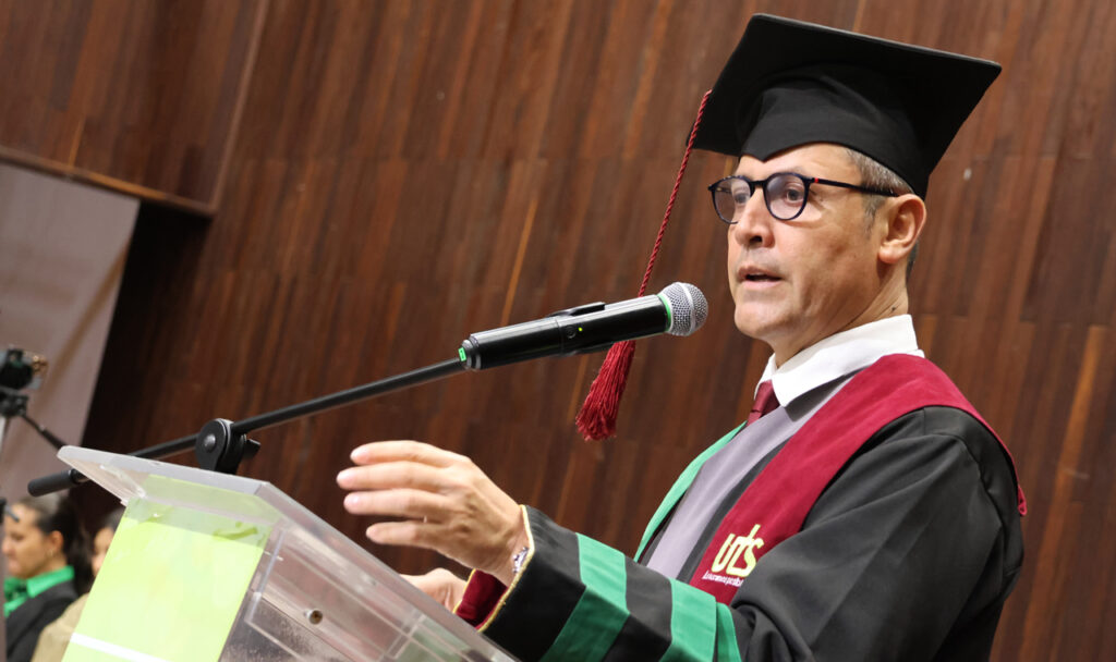 Un directivo de la UTS, con toga, habla desde el atril en la ceremonia de grados.