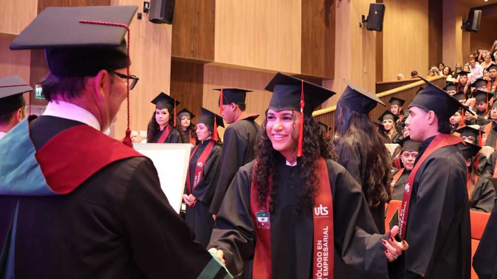Una graduada sonríe durante la ceremonia de grado de la UTS